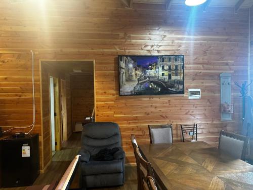 a dining room with a table and a television on a wall at Cabañas quilquico spa in Quilquico