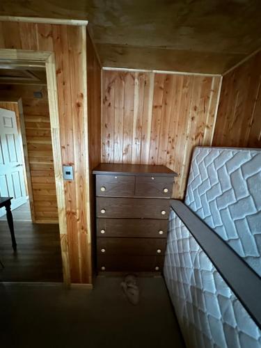 a bedroom with a bed and a dresser in a cabin at Cabañas quilquico spa in Quilquico