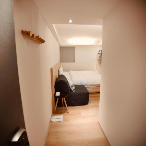 a small room with a bed and a chair at Fooyee Hotel - Yonghe in Yonghe
