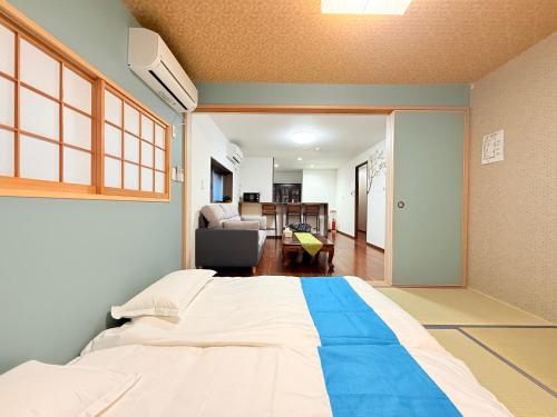 a bedroom with a large bed and a living room at 風花Fuka民泊大森西002 in Tokyo
