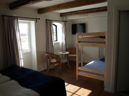 a bedroom with a bunk bed and a desk at Ramsjögård Hotell in Rammsjö