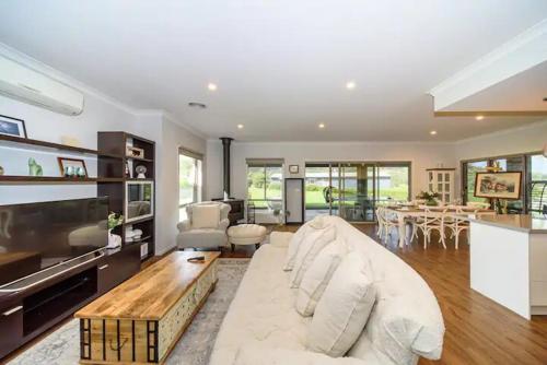 a living room with a white couch and a table at Family-Friendly Gorgeous Farm House TF1952 in Dixons Creek