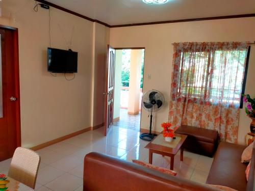 a living room with a couch and a table at Linda's Apartment and Transient in Alaminos