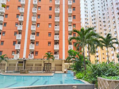 an apartment building with a swimming pool in front of it at Room 88 Kemang View Apartment Tower Flamboyant in Pekayon Satu