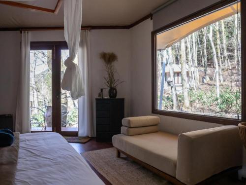 a bedroom with a couch and a large window at LATERAL - Vacation STAY 36594v in Shiojiri