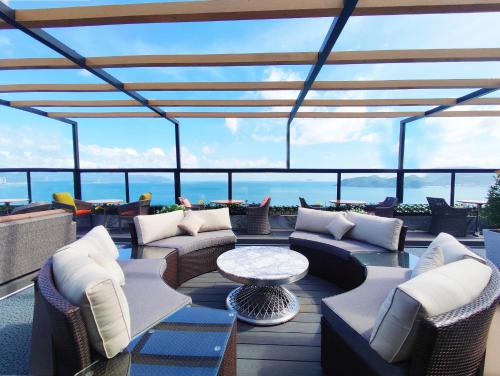 a patio with couches and chairs and a table at Queen Ann Nha Trang Hotel in Nha Trang