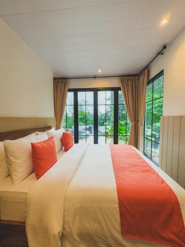 a bedroom with a large bed with red pillows at Arunika Villa in Ciloto