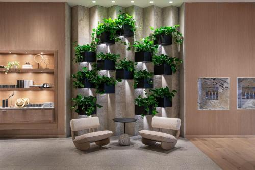 a room with chairs and potted plants on a wall at The Westin Sacramento Riverfront Hotel & Spa in Sacramento