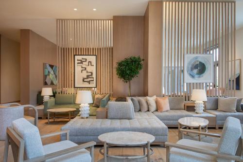 a living room with blue couches and chairs at The Westin Sacramento Riverfront Hotel & Spa in Sacramento