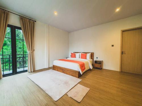 a bedroom with a bed and a large window at Arunika Villa in Ciloto