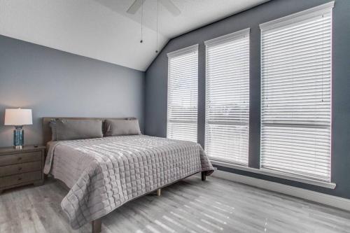 a bedroom with a bed and two large windows at Rockwall Getaway for 6 in Rockwall