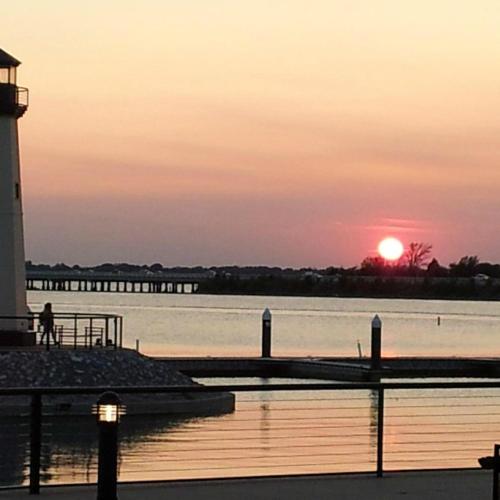 a person standing on a dock next to a lighthouse at Rockwall Getaway for 6 in Rockwall