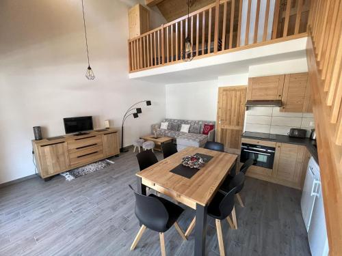 Il dispose d'une cuisine et d'un salon avec une table et des chaises en bois. dans l'établissement Confort moderne avec mezzanine près du téléphérique - FR-1-464-247, à Pralognan-la-Vanoise