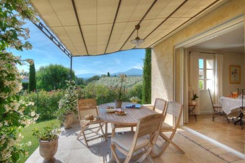 un patio avec une table et des chaises et une vue dans l'établissement L,olivaie Côté Jardin, à Saint-Paul-de-Vence