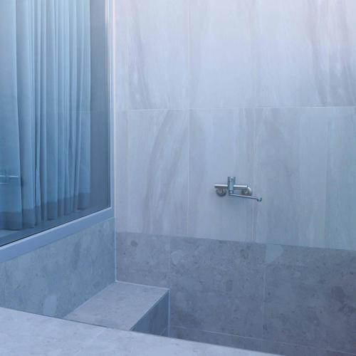 a shower with a faucet in a bathroom at Geoje Osong 815 pension in Geoje