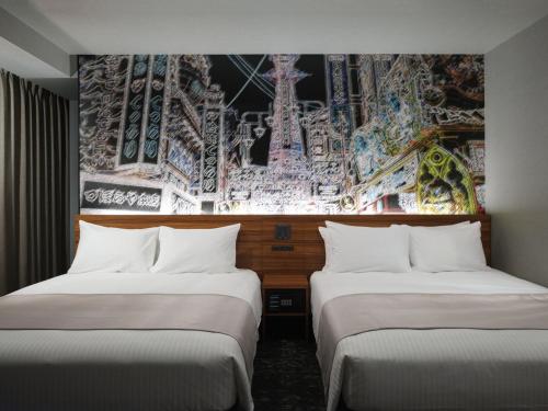 two beds in a room with a painting on the wall at MONday Apart Premium OSAKA NAMBA WEST in Osaka