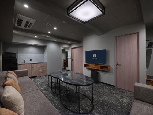 a living room with a table and a couch at MONday Apart Premium OSAKA NAMBA WEST in Osaka