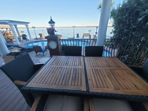 a wooden table and chairs on a deck with the ocean at Lakefront Oasis in Humble