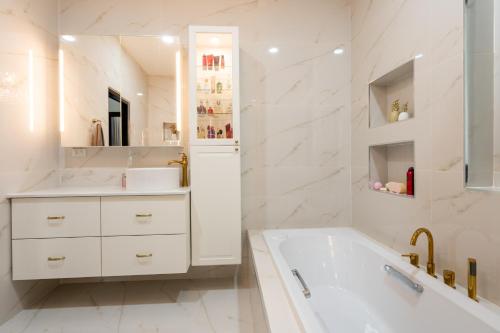 a white bathroom with a tub and a sink at Mellies Home in Ko Lanta Yai