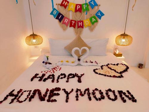 a bed with a happy anniversary cake on it at Elephant Beach Club & Resort Samui in Chaweng
