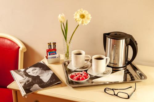 a tray with two cups and a coffee maker on a table at Ottaviano Guest House in Rome