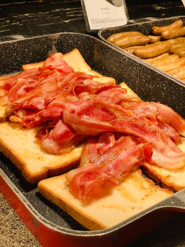 a pan of food with bacon on bread and cheese at Crowne Plaza Huangshan Yucheng by IHG in Huangshan