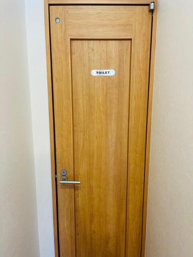 a wooden door with a sign on it at Nest Kisarazu in Kisarazu