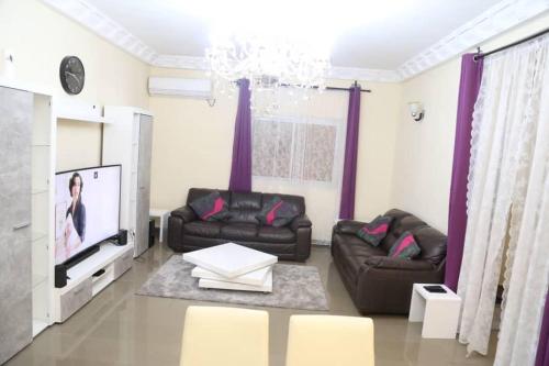 un soggiorno con un divano e una TV di Fots Appartement a Yaoundé