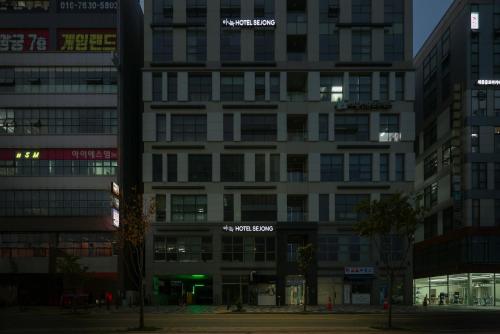 a tall white building with signs on it at night at Aank Hotel Sejong in Sejong