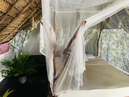 a bed in a room with a mosquito net at The Forest Edge Resort in Dambulla