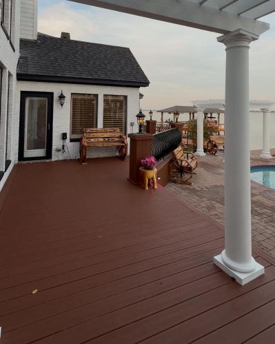 a wooden deck with a house and a pool at Lakefront Oasis in Humble
