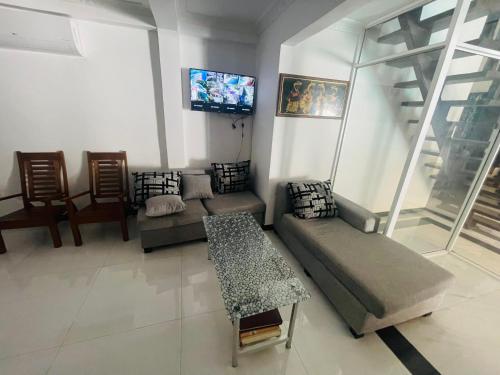 a living room with a couch and a tv at Villa in Chilaw