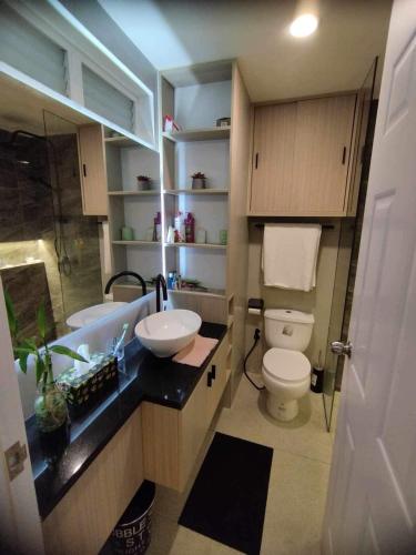 a bathroom with a sink and a toilet and a tub at Lauriz Place at Amani Grand Resort and Residences in Lapu Lapu City