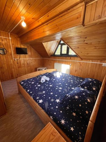 a bedroom with a bed in a wooden cabin at Casa Roxana in Predeal