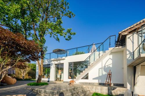 a house with glass walls and a staircase at Kunming Mountain Wowo Hefeng Dieyuan B&B in Kunming