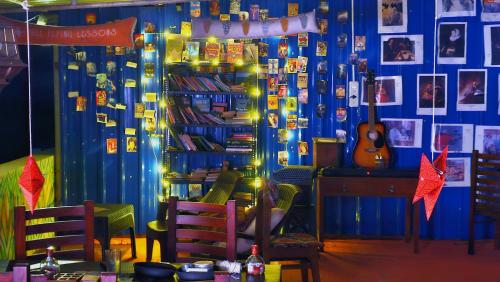 a room with a shelf of books and a guitar at Frozen Monks in Kodaikānāl
