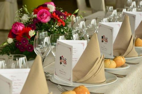 a table with plates and wine glasses and flowers at Hotel Salobreña Suites in Salobreña
