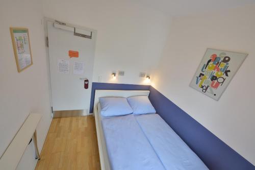 a bed in a room with a blue bed frame at Townside Hostel Bremen in Bremen
