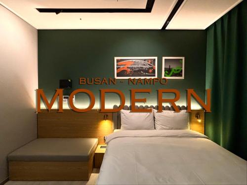 a hotel room with a bed and a sign on the wall at Brand New Residence with Family in Busan