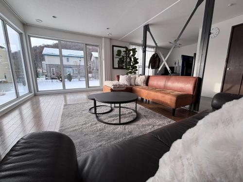a living room with a couch and a table at Perfect Winter Villa Retreat - 14 minutes to downtown in Sapporo