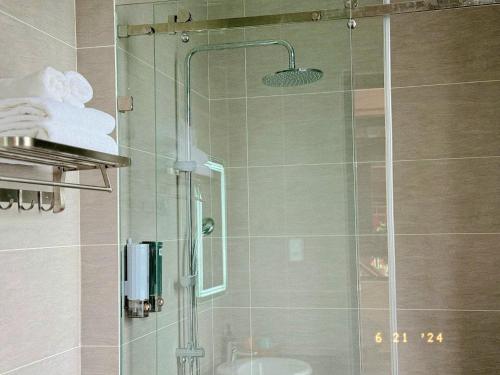 a bathroom with a glass shower with a sink at Sunflower Garden Homestay Đà Lạt in Xuan An