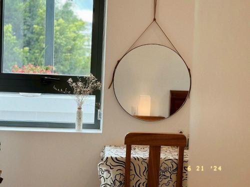 a mirror hanging on a wall next to a window at Sunflower Garden Homestay Đà Lạt in Xuan An