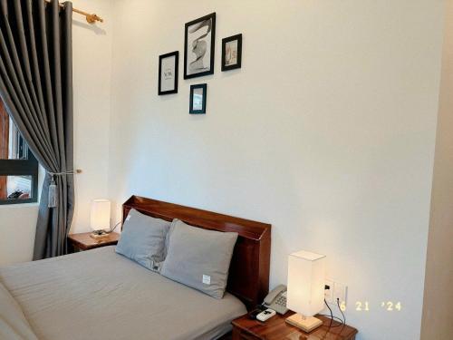 a bedroom with a bed with two night stands and two lamps at Sunflower Garden Homestay Đà Lạt in Xuan An