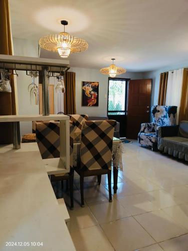 a dining room and living room with a table and chairs at Transient inSan Pablo Laguna by Asuncion in San Pablo