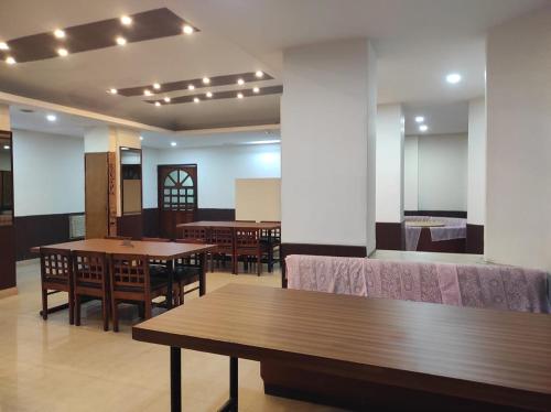 a dining room with tables and chairs and lights at Hotel Ambarish Grand Residency in Guwahati