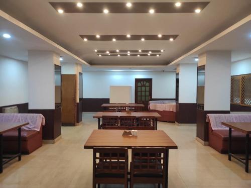 a room with tables and couches in a building at Hotel Ambarish Grand Residency in Guwahati