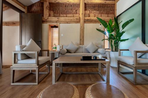 a living room with a couch and chairs and a table at Kunming Mountain Wowo Hefeng Dieyuan B&B in Kunming