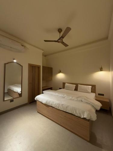 a bedroom with a large bed with a ceiling fan at Radhe Krishna Residency Nearest Triveni Sangam in Prayagraj