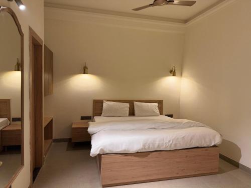 a bedroom with a bed with white sheets and a ceiling at Radhe Krishna Residency Nearest Triveni Sangam in Prayagraj