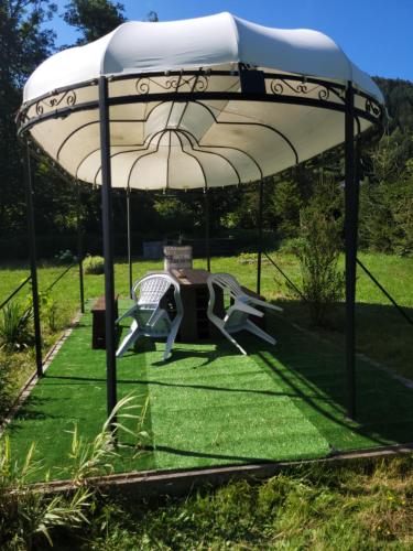a gazebo with aroller in the grass at Gîtes Les Grandes Voies - Clé Vacances in Le Ménil